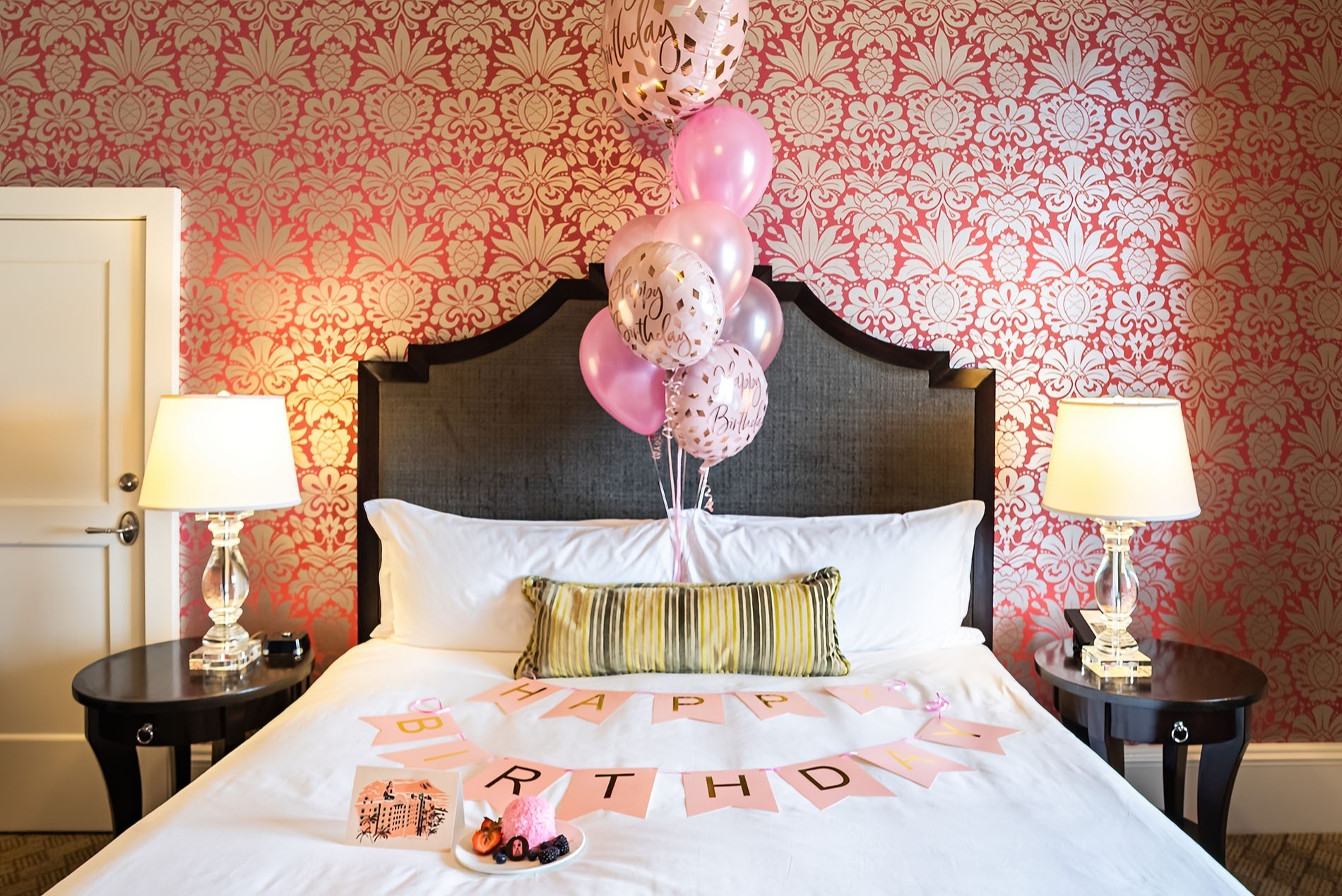 ピンクのバルーンと“HAPPY BIRTHDAY”のガーランドで飾られた、ロイヤル ハワイアンの客室のベッドルーム