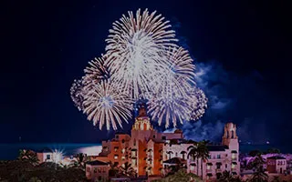 夜空を彩る花火とライトアップされたロイヤルハワイアンホテル
